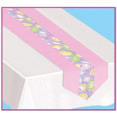 a pink and blue table runner with hearts on the edge is sitting on top of a white box