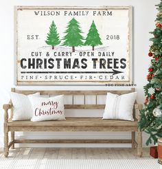 a wooden bench sitting next to a christmas tree in front of a sign that says, merry