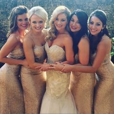 four beautiful women in gold dresses posing for a photo together with their arms around each other