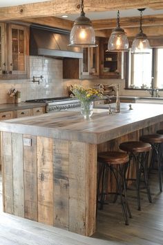 a kitchen island made out of wooden planks with lights hanging from the ceiling over it