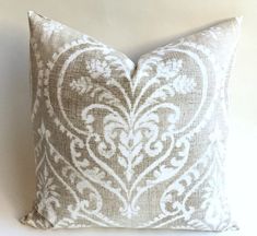 a decorative pillow is shown on a white wall with a brown and white damask pattern