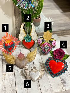 several decorative heart shaped objects sitting on top of a wooden table next to a potted plant