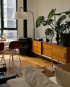 a living room filled with furniture and a fire place next to a large glass window