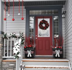 the front porch is decorated for christmas with wreaths and decorations on it's door