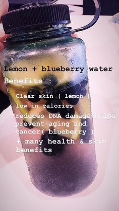 a person is holding a blueberry water in a mason jar with the words lemon and blueberry water on it