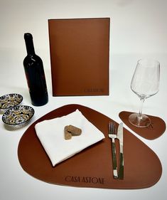 a table setting with wine, silverware and corkscrews