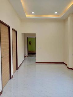 an empty room with white marble floors and wooden doors on either side of the door