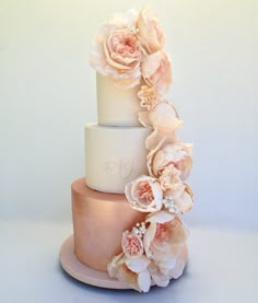 a three tiered cake with pink flowers on top