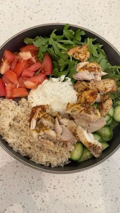 a bowl filled with rice, meat and veggies on top of a table