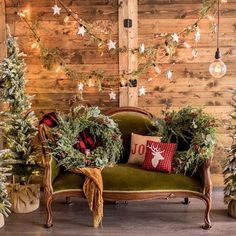 christmas decorations and trees are on display in front of a wood paneled wall with lights