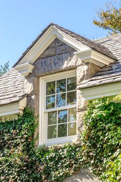 a house with ivy growing on it's side and a window in the middle