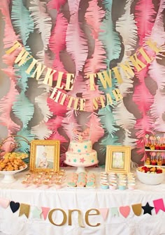 a table topped with cake and desserts next to balloon garlanded wall behind it