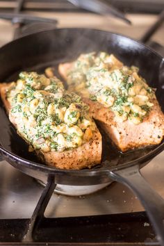 two pieces of fish are cooking in a skillet