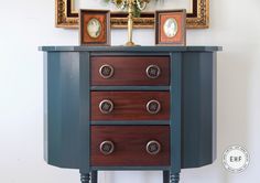 a dresser with three drawers and two framed pictures on top