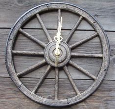 an old wooden wagon wheel hanging on the side of a building