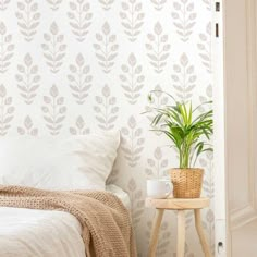 a bedroom with a plant on the side table