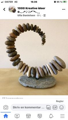 there is a sculpture made out of rocks on the ground with a rock in the middle