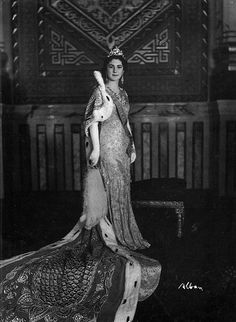 an old black and white photo of a woman in a dress holding a stuffed animal