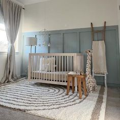 a baby's room with a giraffe statue next to the crib