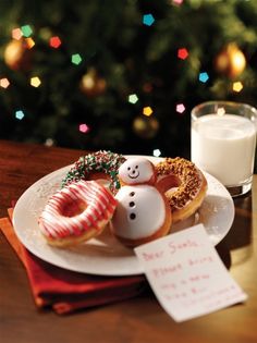 a white plate topped with donuts covered in frosting next to a glass of milk