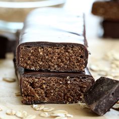 two chocolate bars stacked on top of each other with oats scattered around the edges