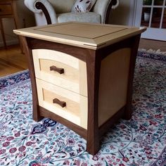 a wooden table with two drawers on top of it next to a chair and rug