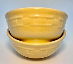 two yellow bowls sitting next to each other