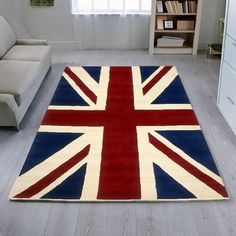 a living room with white furniture and a large rug on the floor that has a british flag design