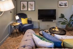 a living room filled with furniture and a flat screen tv mounted to the side of a wall