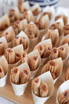 small desserts are lined up on a wooden tray