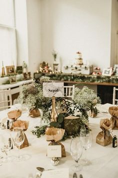 the table is set with wine bottles and place cards