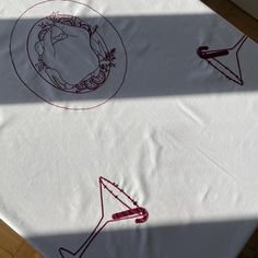 the table cloth has been drawn with red ink and is sitting on top of a wooden floor