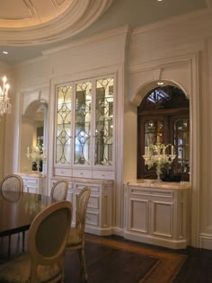 an elegant dining room with white walls and wood floors