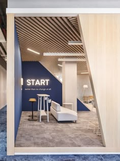 the interior of a modern office with blue walls and white furniture, along with wooden slats on the ceiling