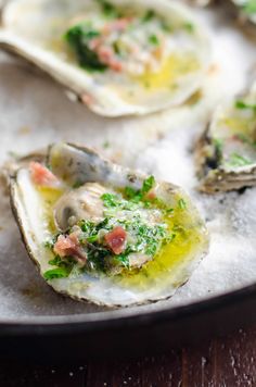 three oysters with parsley and other toppings in a pan on the table