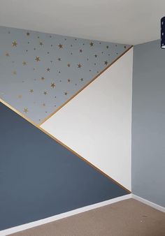 an empty room with blue walls and gold stars on the wall, along with carpeted flooring