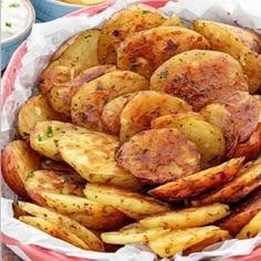 a red bowl filled with potatoes on top of a table