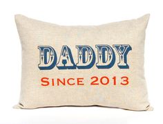 a pillow with the words daddy since 2013 printed in red, white and blue on it