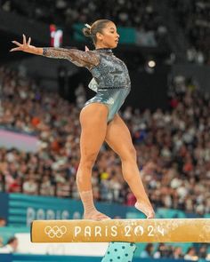 a woman balances on the beam during a competition