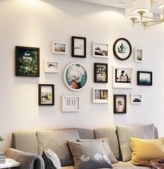 a living room filled with lots of pictures on the wall above a couch and coffee table