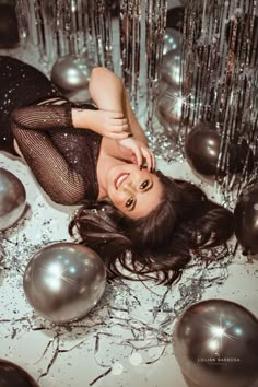 a woman laying on the ground surrounded by balloons