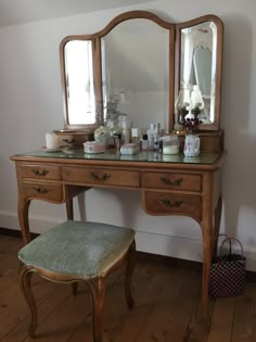 a dressing table with two mirrors and a stool