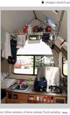 the inside of a camper with an oven and stove top in front of it