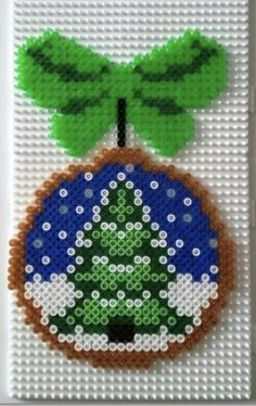 a cross stitch christmas ornament with a green tree on it's top