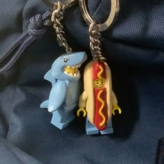 two lego figures are attached to a keychain with a hot dog and ketchup on it