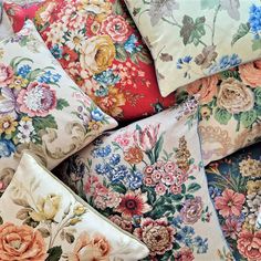 a pile of pillows that have flowers on them