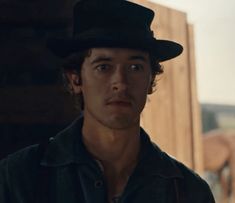 a young man wearing a black hat and shirt