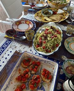 a table topped with plates of food and glasses of wine