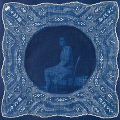 an image of a woman sitting in a chair on a blue background with white lace