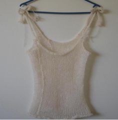 a white tank top hanging on a blue hanger next to a wall with a string attached